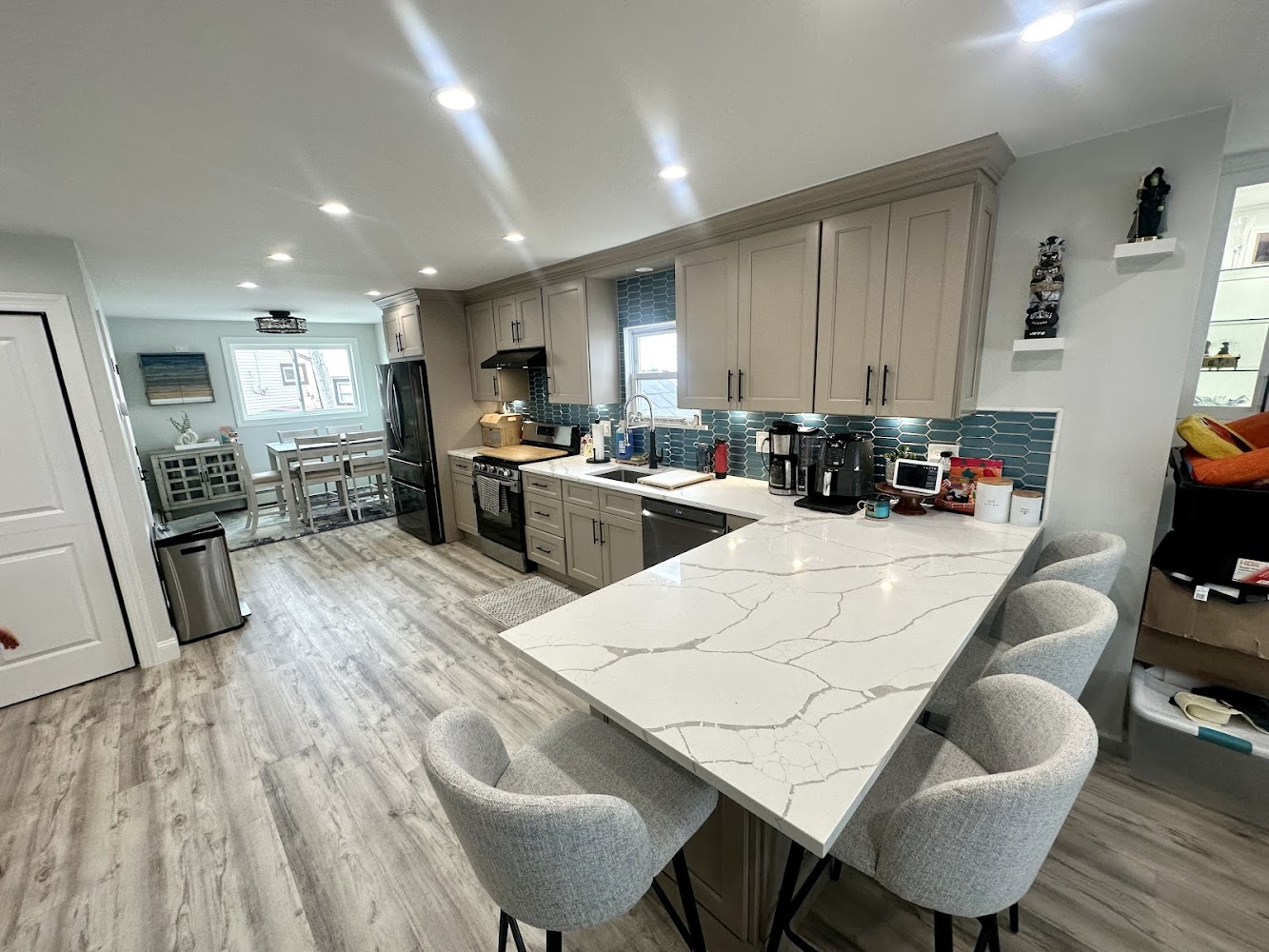 A modern kitchen featuring a white countertop and matching chairs, creating a bright and inviting atmosphere.