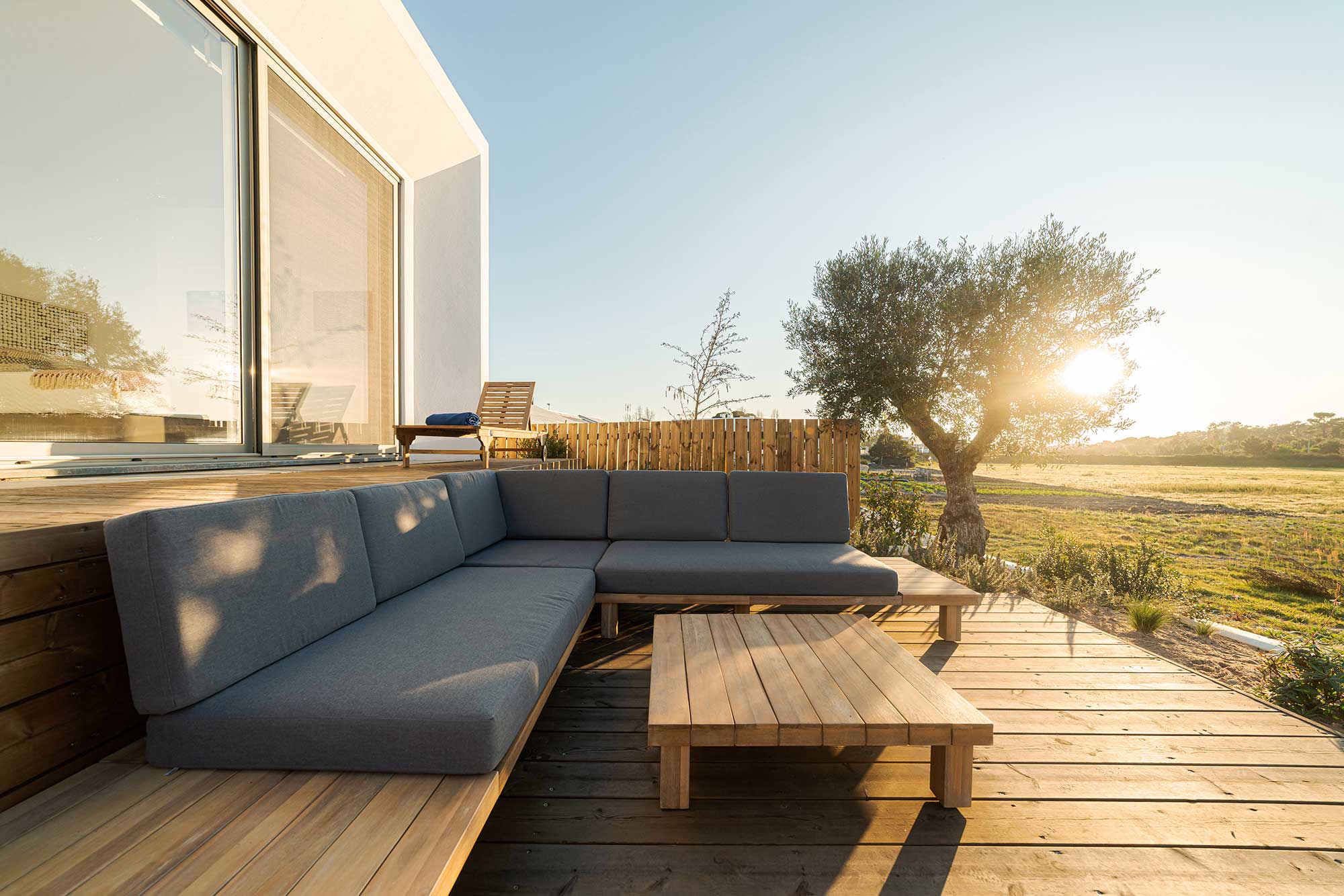 Custom wooden deck with built-in seating in a backyard.