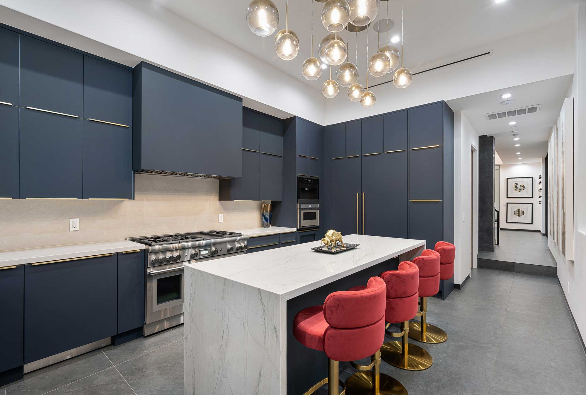 Marble kitchen countertop with a waterfall edge, complemented by modern pendant lighting.