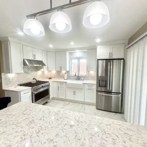 A modern kitchen featuring white cabinets and sleek stainless steel appliances, creating a bright and contemporary atmosphere.