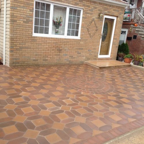 A brick patio featuring a prominent large tile pattern, showcasing a blend of textures and colors in an outdoor setting.