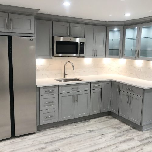 A modern kitchen featuring gray cabinets and sleek stainless steel appliances, creating a stylish and functional space.