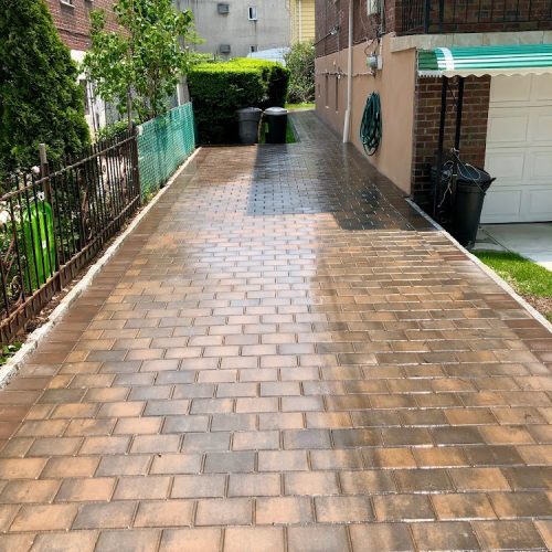 A well-constructed brick driveway seamlessly connects to a charming brick walkway, enhancing the landscape's appeal.