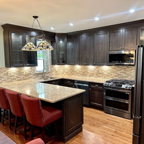 A modern kitchen featuring dark wood cabinets and elegant granite countertops, showcasing a sophisticated design.