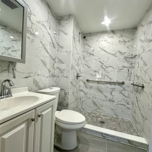 A luxurious bathroom featuring elegant marble walls and flooring, showcasing a sophisticated and modern design.