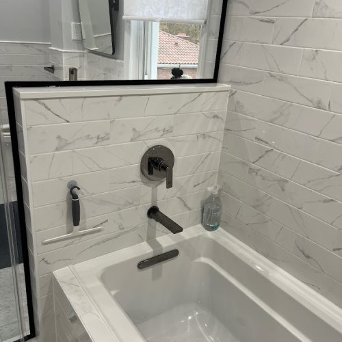 A luxurious bathroom featuring a white marble countertop and an elegant bathtub, exuding sophistication and style.