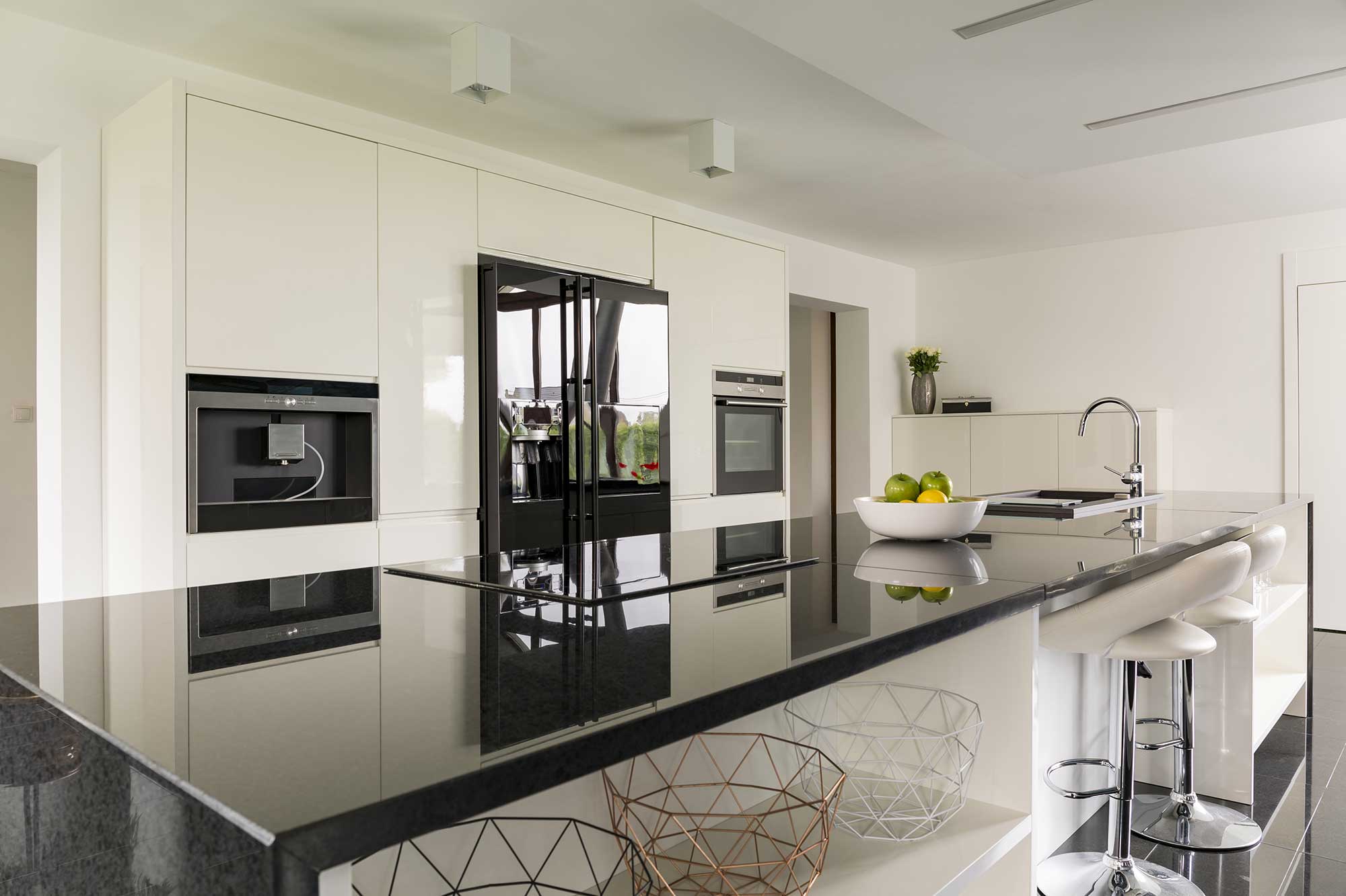 Modern kitchen with sleek white cabinetry, a spacious island, and stainless steel appliances.